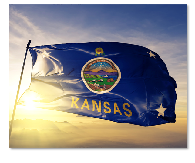 Kansas flag on a flagpole waving as the sun rises behind it